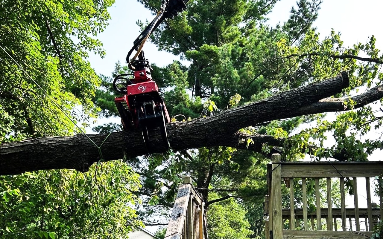 A red grapple saw navigating a narrow Old Town Alexandria street, demonstrating accessibility challenges that affect pricing.