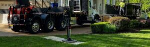 The Green Vista Tree Care crane balanced on a Northern Virginia property's lawn using Alturna mats to protect the grass.